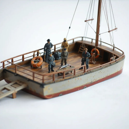 Miniature crew figures posed on a scale model boat deck with realistic clothing and deck details