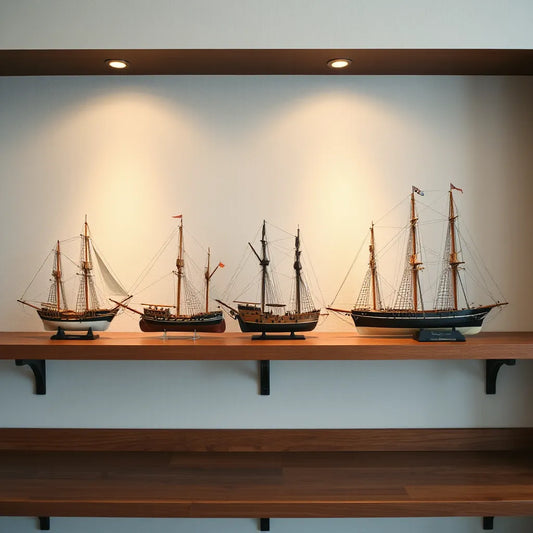 Three detailed historical ship models displayed on a wooden shelf with visible rigging and sails