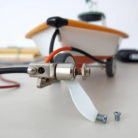 Waterproof RC boat fittings showing rudder linkage, servo connection, and shaft coupling on a model hull.
