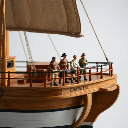 Scale crew figures posed on a model boat deck with lifelike clothing and deck details